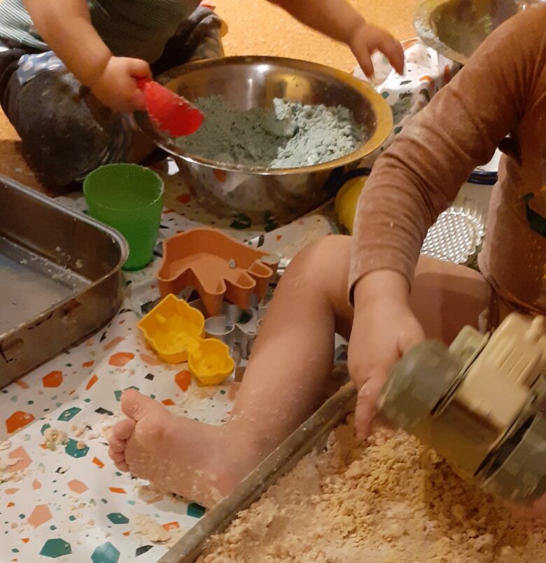 Kinder spielen im inklusiven Spieletreff mit Sand.